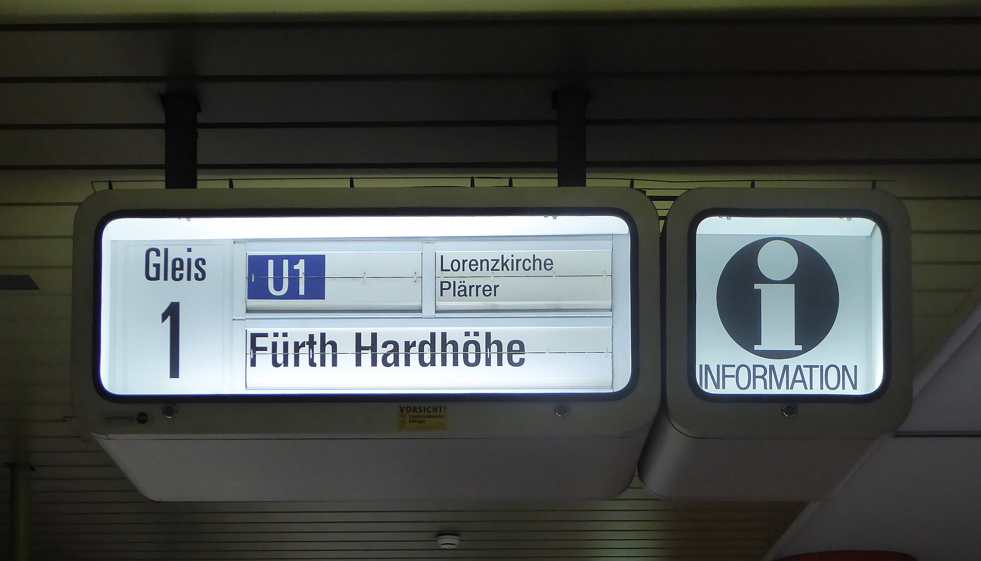 Ein mechanischer Fallblattanzeiger in einem Bahnhof zeigt Abfahrtszeiten und Gleise.